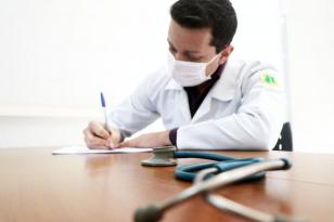 Médico assinando papéis 