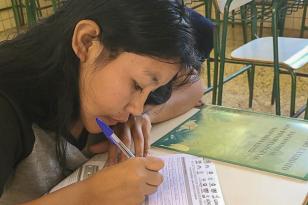 Estudante indígena escrevendo 